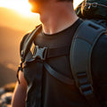 Black backpack chest strap harness with quick-release buckle worn by hiker